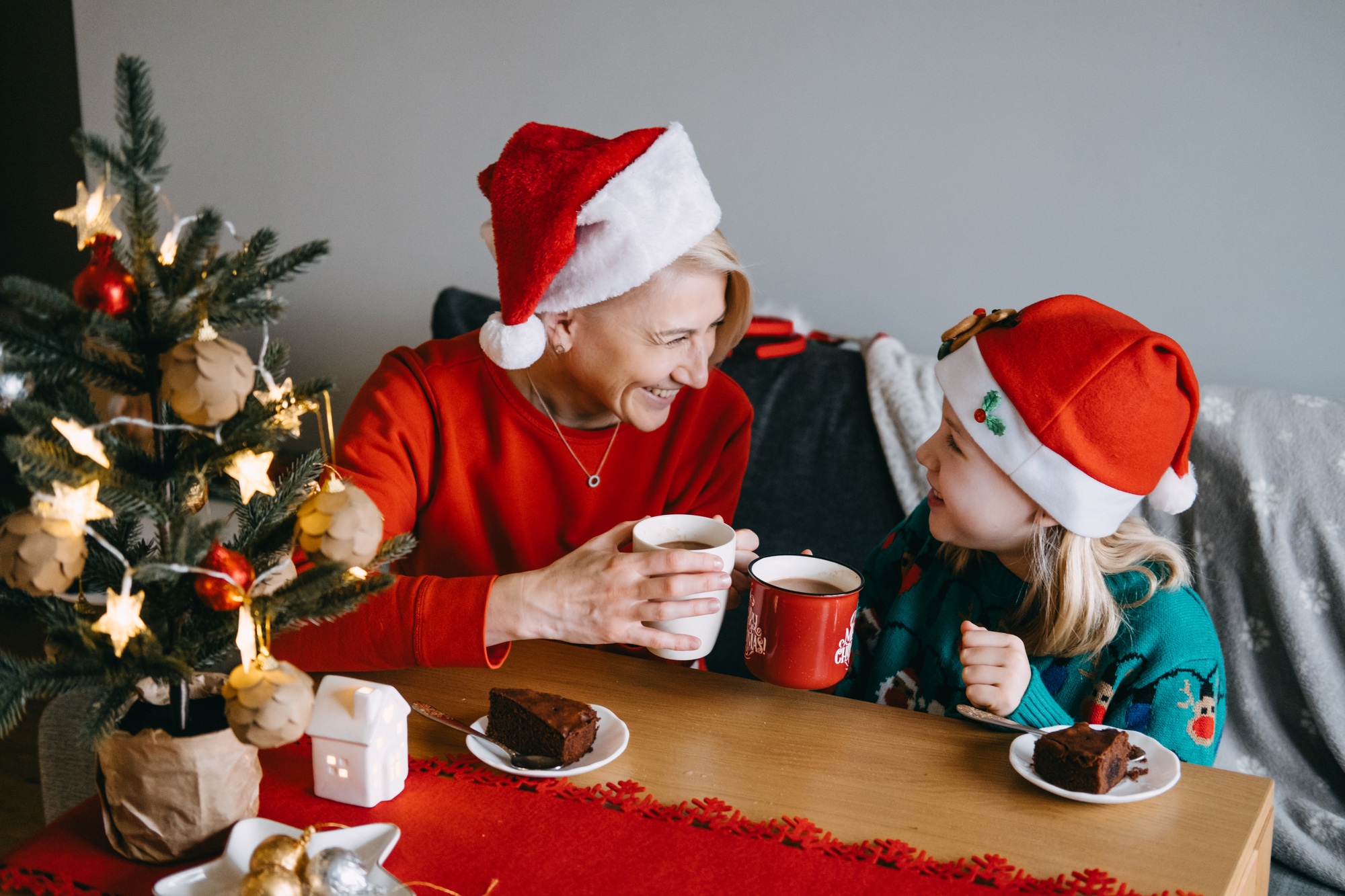 Mother and daughter enjoying Christmas treats together. Holiday desserts, festive food, family