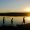 Silhouettes of fishing boys are walking home after fishing the lake in the evening sun